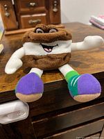 Front view of plush showing face, limbs, colours