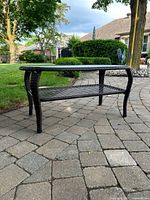 Full view of dark brown resin wicker coffee table on patio