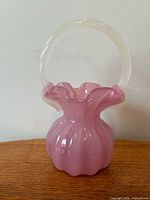 Full view of pink basket vase showing body and handle