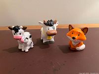 Front view of adult cow, calf, and fox figures