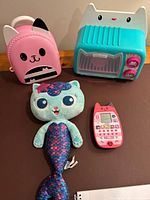 All four items grouped: backpack, oven, plush, phone