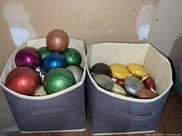 two fabric bins filled with assorted glitter plastic baubles