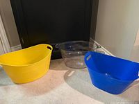 Yellow, clear and blue plastic oval tubs side by side