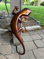 Front view of painted metal lizard wall art showing copper/bronze finish