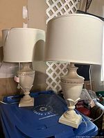 Pair of matching cream resin table lamps with shades displayed together