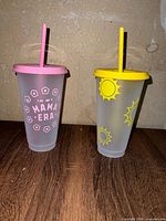 Both tumblers side by side showing color, lids, straws and graphics
