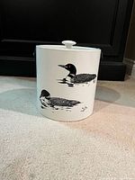 Front view of white enamel ice bucket showing loon design and lid.