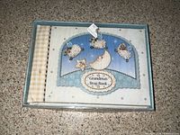 Photo of album in box showing cover design and title