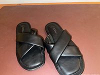 Top view of black slide sandals showing cross-band design and footbeds