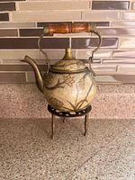 Teapot on stand with lid in place showing full exterior