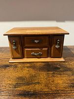 Front view closed showing wood, hardware, pedestal base