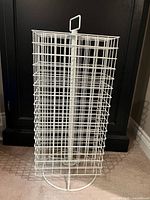 Front view of white wire rotating display rack showing overall structure