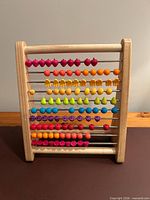 Front view of wooden abacus showing 10 rows of multicolour beads