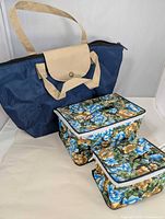 All three items standing: navy tote, large floral bag, small floral pouch