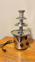 Full view of assembled stainless steel chocolate fountain with power cord