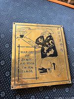 Front view of brass plaque showing illustration, text, mounting holes
