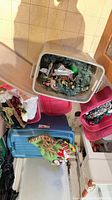 Open storage totes holding wreath, stockings, string lights, ornaments