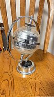 Full view of globe barometer on chrome stand