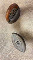 Top view of both sad irons, showing full iron with wooden handle and separate iron base, lettering and wear visible