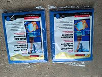 Two unopened ProPainter drop cloth packages on floor showing front labels and grommets