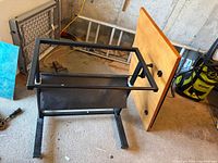 Puzzle table disassembled showing wood top panel, metal frame, base parts
