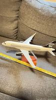 Side view of Bombardier CSeries/A220 model on stand with tape measure showing length