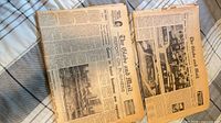 Two folded 1970s Globe and Mail newspapers on plaid surface showing front pages and aging