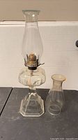 Full view of oil lamp with installed chimney and spare chimney beside