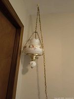Full view of hanging lamp showing shade, chain, cord and lower finial