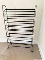 Full view of 10-tier metal shoe rack showing side frames, shelves and casters