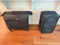 Front view of both suitcases showing size difference and wheel types