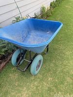 Overall view of blue two-wheel garden cart on lawn