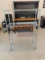 Front view of chrome wire shelving unit showing four tiers and vertical posts