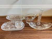 group shot of all six clear pressed glass pieces