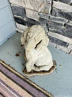 Front view of concrete dog statue showing overall form and condition