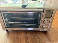 Front view of Emeril Lagasse Power AirFryer 360 showing controls, glass door, attached cord