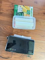 Top view of FoodSaver vacuum sealer with tray of seal rolls