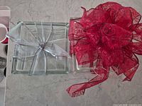 Top view of both clear glass blocks showing silver and red ribbon bows