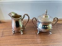 Creamer and covered sugar bowl side by side