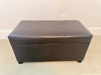 Front view of dark brown faux leather storage ottoman