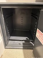 Open interior of one safe showing shelf slots and clean condition