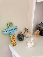 Overview showing cross plaque, glass pumpkin, beige pumpkin, swan, dog figurine