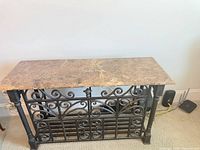 Front view of entire console table showing marble top and ornate cast iron base