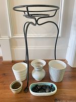 Entire lot showing plant stand, three planters, frog vase, dish with stones