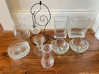 All ten glass and metal pieces arranged on wood floor
