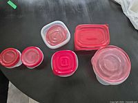 Top-down view of five assembled containers showing variety of shapes and red lids