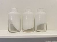 Front view of three white-clear glass vases