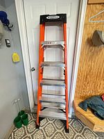 Full view of Werner 6 ft fiberglass step ladder standing closed