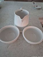 creamer with large chip and two bowls