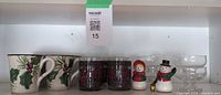 All items on shelf: 4 holly mugs, 4 Season's Greetings tumblers, 4 glass dessert dishes, 2 snowman shakers